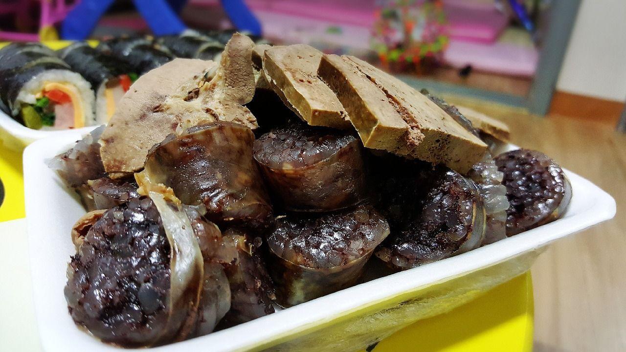 照片展示韓國街頭小吃血腸（순대），搭配辣炒年糕，強調其獨特的口感和韓國布帳馬車的魅力。